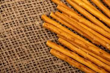 Salty bread strips scattered on a background of coarse homespun fabric.