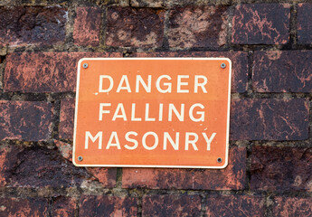 Danger Falling Masonry sign on a old red brick building