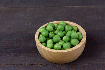 Pea eggplant or turkey berry in wooden bowl on wooden background. Solanum torvum is ingredients for cooking Thai food. 