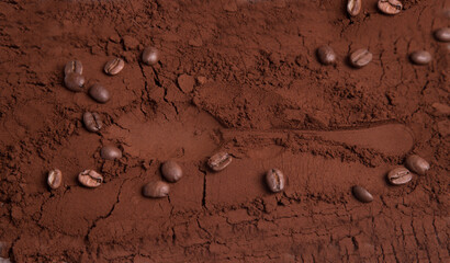 Close-up of roasted ground coffee with coffee beans and the imprint of a coffee spoon. Background...
