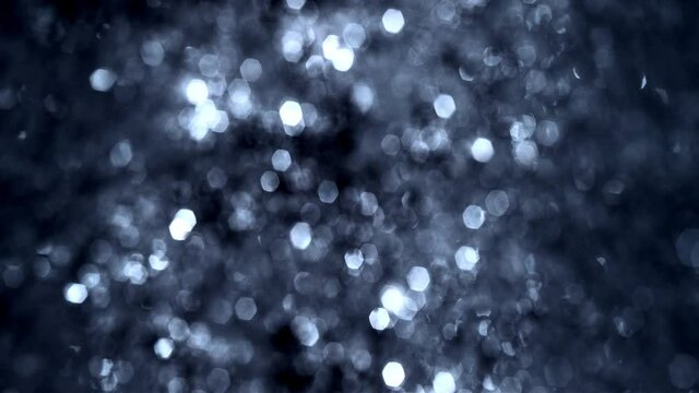 Full frame defocused and Bokeh silver and blue diamond tinsel glow. Looped festive luxury gala glitter abstract bokeh background for rare earth, luxury success and metal element concepts.