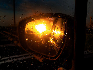 夕立が止みバックミラーに写る夕陽