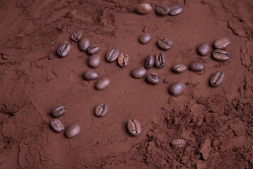 Scattered coffee beans on ground roasted coffee. Food background