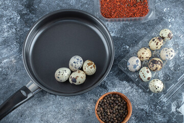 Fresh organic quail eggs on frying pan ready to cook