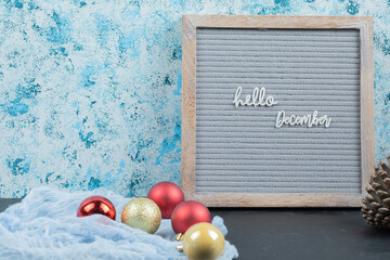 Hello december phrase on the grey board with christmas bubbles around