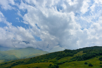 Fototapeta na wymiar Beautiful mountain peaks of the North Caucasus against the backdrop of a blue cloudy sky. Republic of North Ossetia - Alania