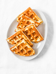 Cottage cheese waffles - delicious sweet dessert on a light background, top view