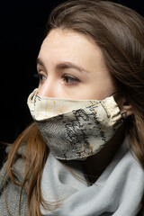 girl in a medical mask with a scarf on a black background
