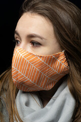 girl in a medical mask with a scarf on a black background