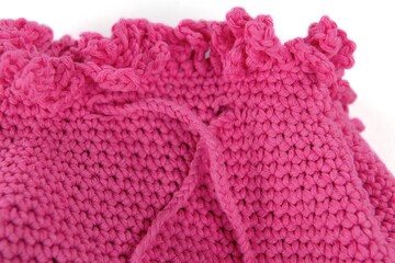 Handmade pink knitted bag on grey background. Close-up. Cotton bag. Cotton lace