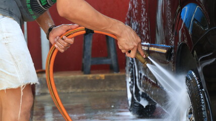 worker car cleaning, spraying and wiping, at his workplace