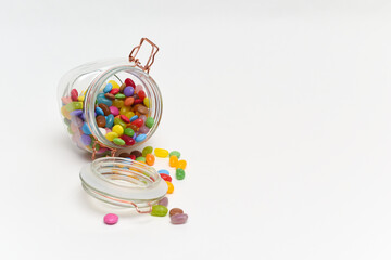 Sweets in a jar isolated on white background as the candy spills out