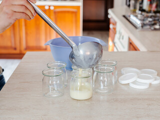 Woman making yogurt at home. Soy yogurt, vegan recipe. Cooking at home
