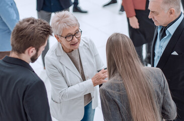 Group of modern business people chatting during coffee break