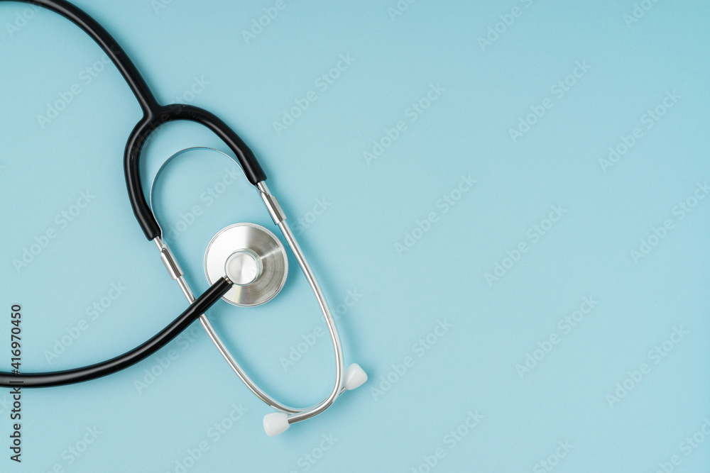 Wall mural Stethoscope on blue background with a copy space.