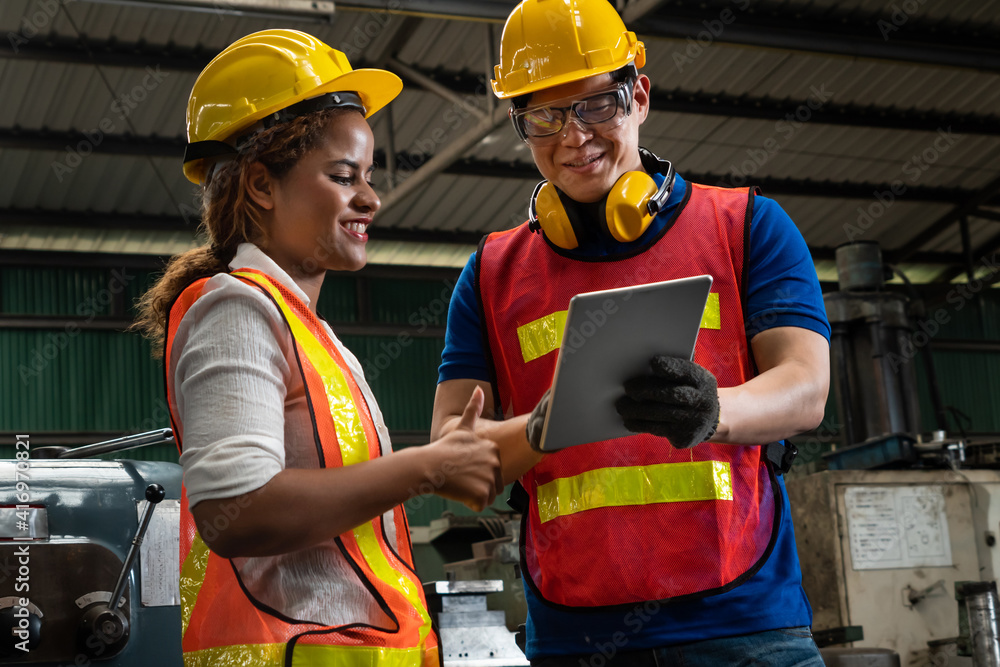 Poster two skillful factory engineer or worker discussing project on tablet computer . industrial people an
