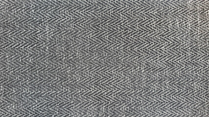 black herringbone tweed fabric pattern background with closeup on laminated material .wool fabric texture. 