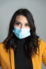 Beautiful young Latina business woman wearing a protective mask. 