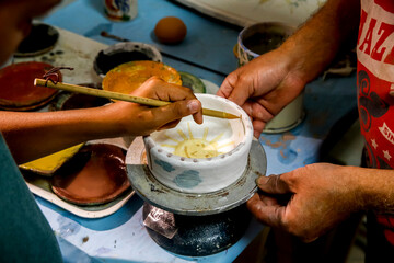 Fototapeta na wymiar Ceramic pottery workshop in Tricase, Puglia, Italy. Potter teaching a child. 18.09.2018