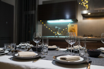 family dinner in a cozy Scandinavian country house. an example of a festive table setting with a white and gray tablecloth.