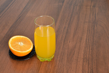 A glass of juice and half an orange.