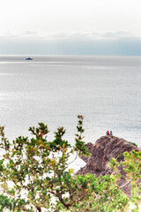 Two tourist sitting on rocky cliff and enjoying beautiful view