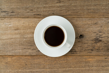 A cup of coffee on a shabby wooden board background. Flat lay.