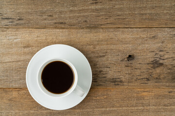 A cup of coffee on a shabby wooden board background. Flat lay. Copy space.