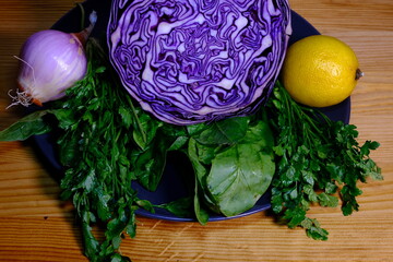 sliced red cabbage, lemon, onion, parsley, spinach in a plate. fresh vegetables concept.