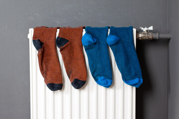 Colorful socks are being dry on the radiator