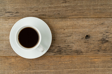 A cup of coffee on a shabby wooden board background. Flat lay. Copy space.