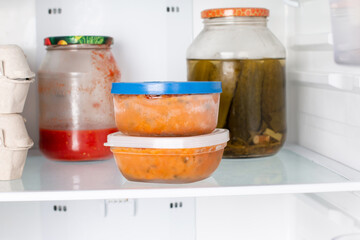 Frozen sauce in a container in the refrigerator