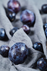 Scattered plums on gray tablecloth