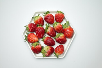 Heap of fresh strawberries in white ceramic dish