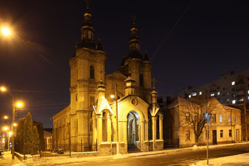 Fototapeta na wymiar Kremenchuk, Ukraina - 02.27.2021: Roman Catholic Church in the neo-gothic style. Brick religious building. Christian temple in the evening city. Place of religious rites and gatherings of believers