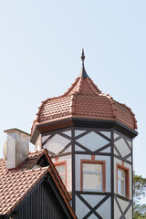 Facade of house with tower and domed roof spire at top. Half-timbered decoration. German architecture. Close-up, selective focus