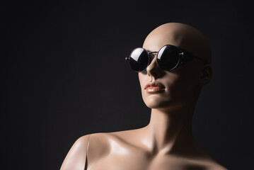 Stylish sunglasses on the woman dummy close up on a black showcase background. Beauty and fashion concept. Sunglasses sale.