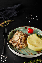 mashed potatoes with mushrooms on black textured background