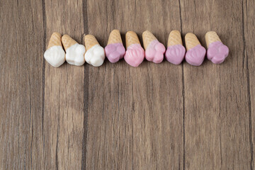 Pink white icecream shape jellybeans on a wooden board