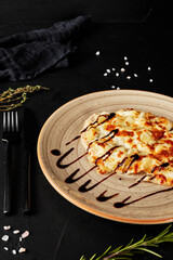 chicken chop with pineapple and cheese on black textured background