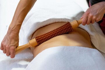 Masseuse giving a wood massage therapy massage to a client