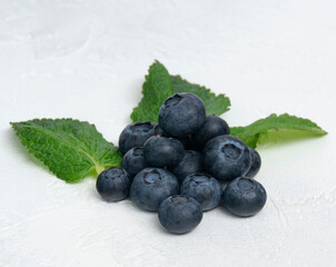 Blueberries are on the green leaves of mint