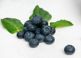 Blueberry berries with mint leaves in water droplets are on the table
