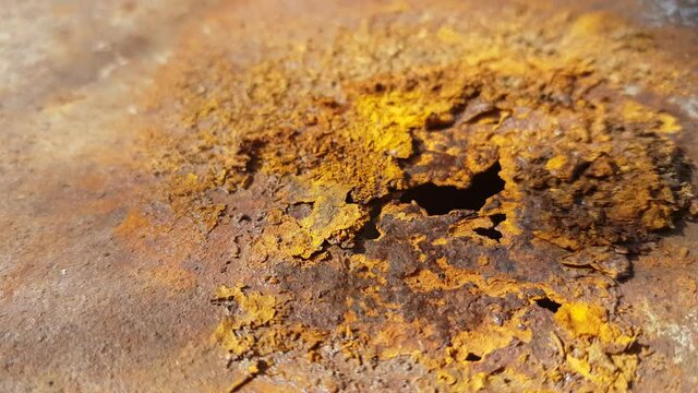 close-up of rust with a hole in the iron sheet.
