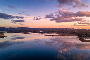 Drone aerial view of a lake reservoir of a dam with perfect reflection on the water of the sunset in Sabugal, Portugal
