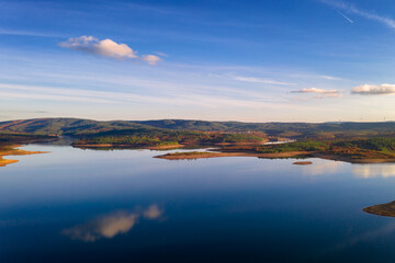 Drone aerial view of a lake reservoir of a dam with perfect reflection on the water of the sky in Sabugal, Portugal