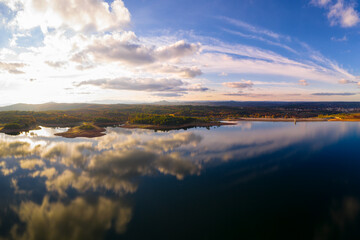 Drone aerial view of a lake reservoir of a dam with perfect reflection on the water of the sky in Sabugal, Portugal
