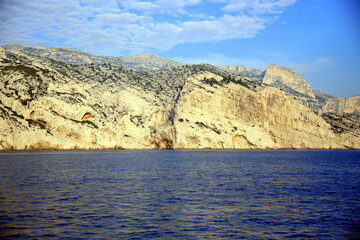 Fototapeta na wymiar Front view of the fractured rock face, overlooking the blue sea, Parc National des Calanques, Marseille, France