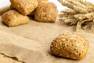 Baguette bread. Rye bakery with crusty loaves and crumbs. Fresh loaf of rustic traditional bread with wheat grain ear or spike plant on natural cotton background. Concept - Cooking at Home.