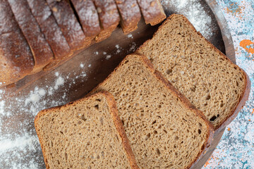 Slices of brown bread slices on wooden plate